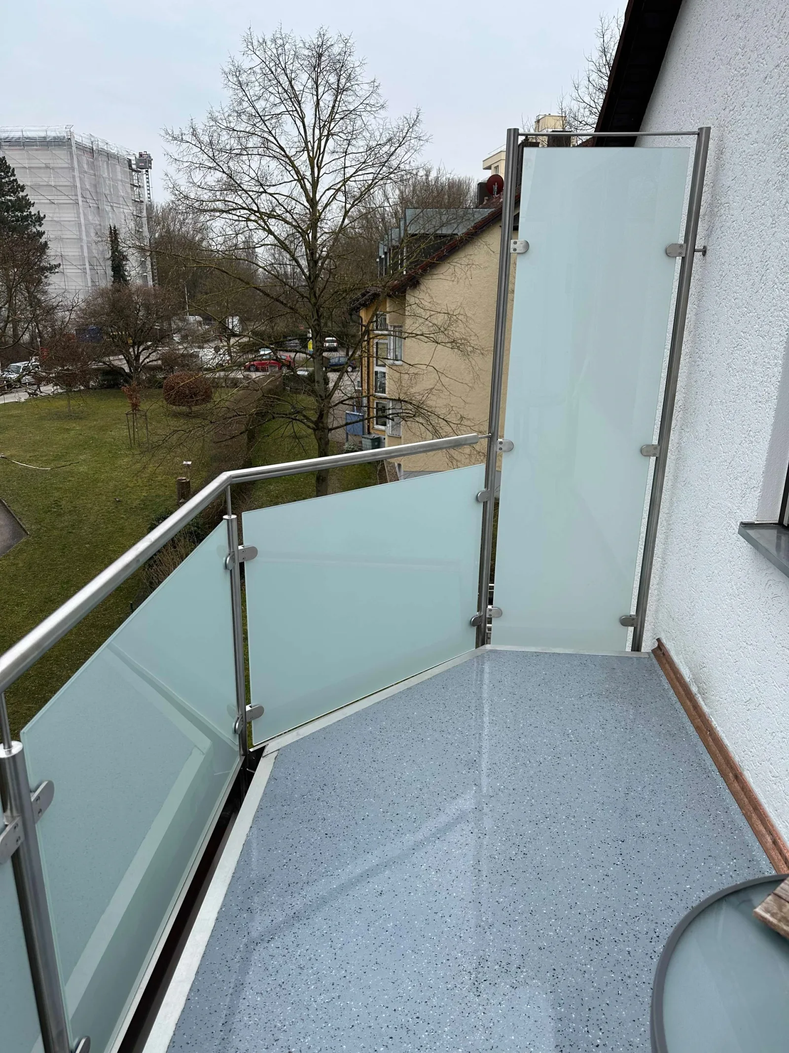 Edelstahl-Glasgeländer mit Milchglas auf einem Balkon